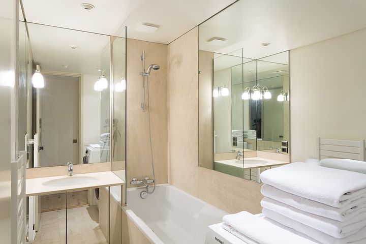 a photo of a bathroom with shower and tub and full of mirros