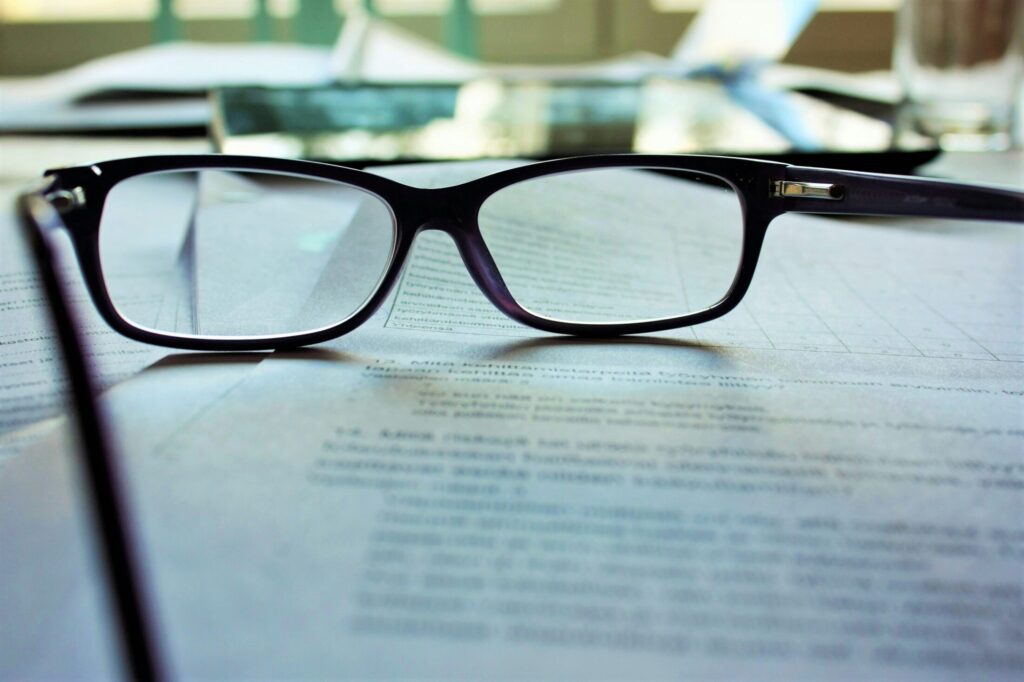 black framed eye glasses a book