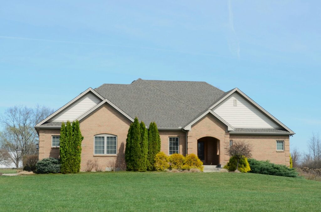 a suburban brick house with a well kept lawn